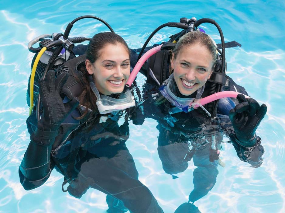 Two certified divers enjoying a fun dive and exploring the beautiful coral reefs and marine life of Mabul Island.