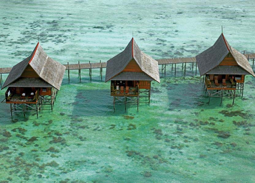 Breathtaking aerial skyview of Kapalai water village resort, showing the network of chalets built over a shallow reef.