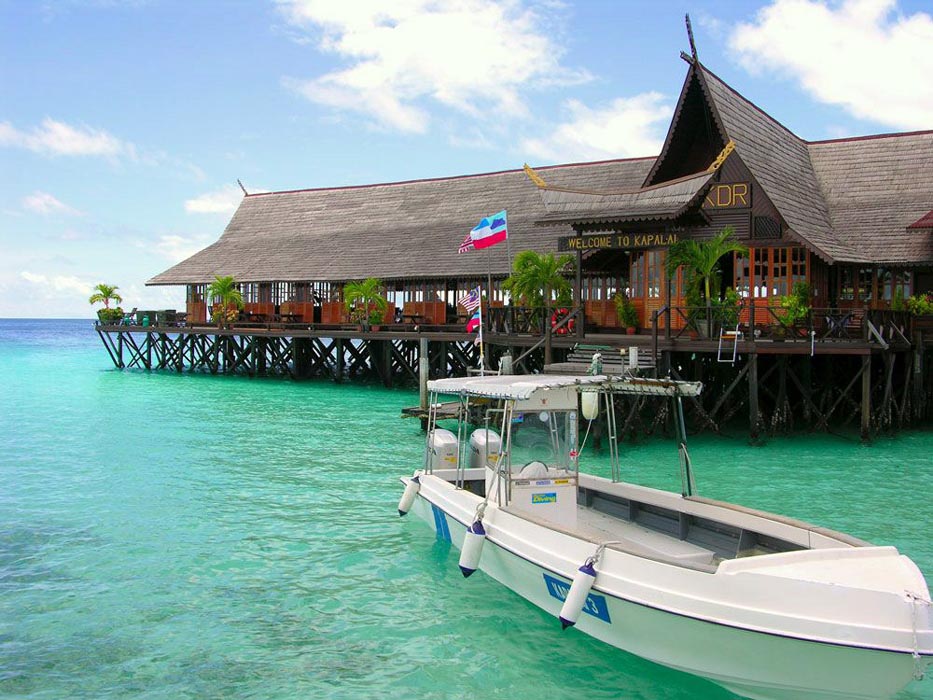 Dive boat moored at the jetty of the Kapalai overwater resort, with the stunning turquoise Celebes Sea in the background.