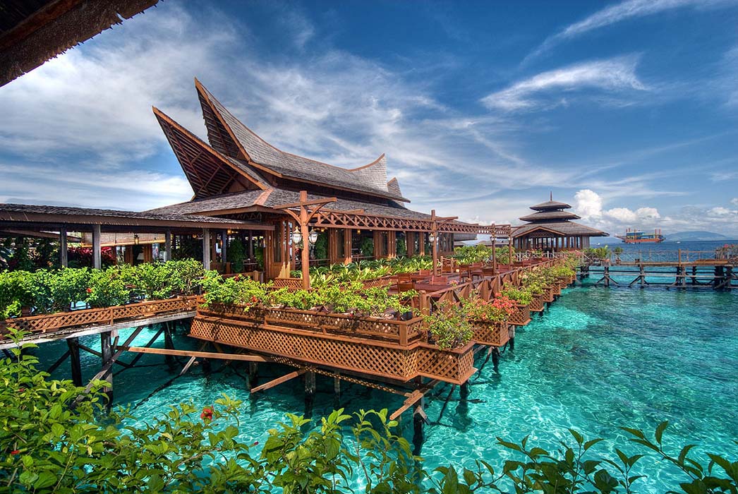 The magnificent fine-dining restaurant at Mabul Water Bungalows, showcasing stunning traditional architecture built over the turquoise sea.