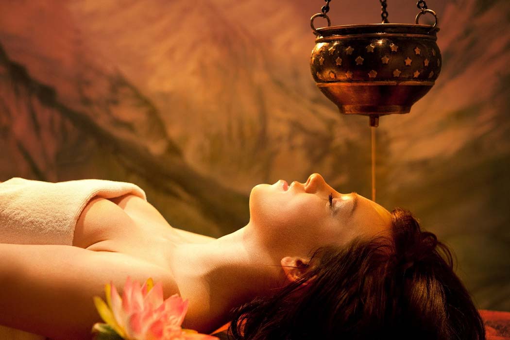 Serene spa setting with candles, essential oils, and rolled towels, inviting guests to relax their body and soul during their Mabul and Sipadan vacation.