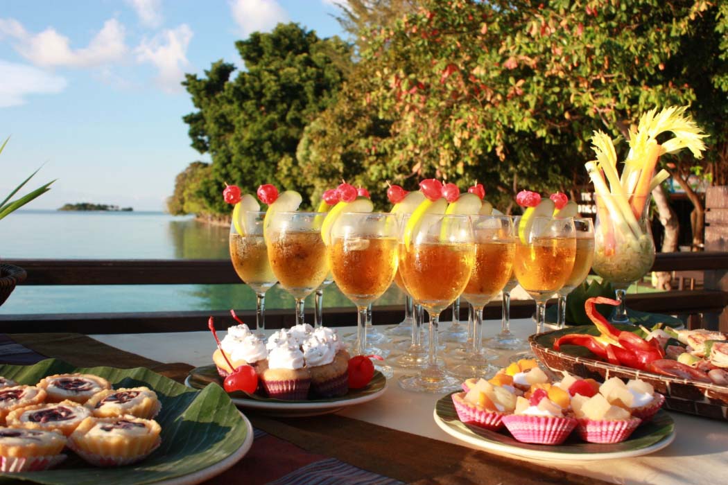 Delicious buffet spread set up at Mataking on a chalet balcony for a special dining event, with a Semporna island in the background.