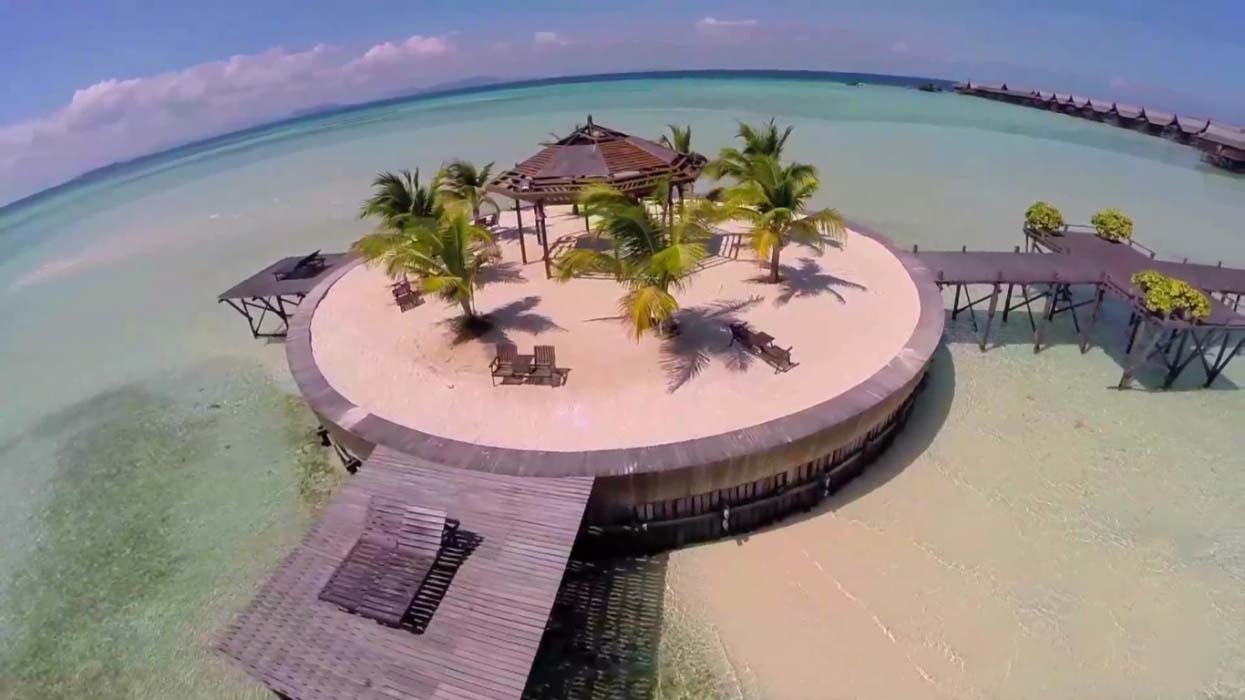 Stunning aerial view of the iconic Kapalai overwater resort, showcasing its unique layout and idyllic location in the Celebes Sea including a little bit of sandy beach at low tide.
