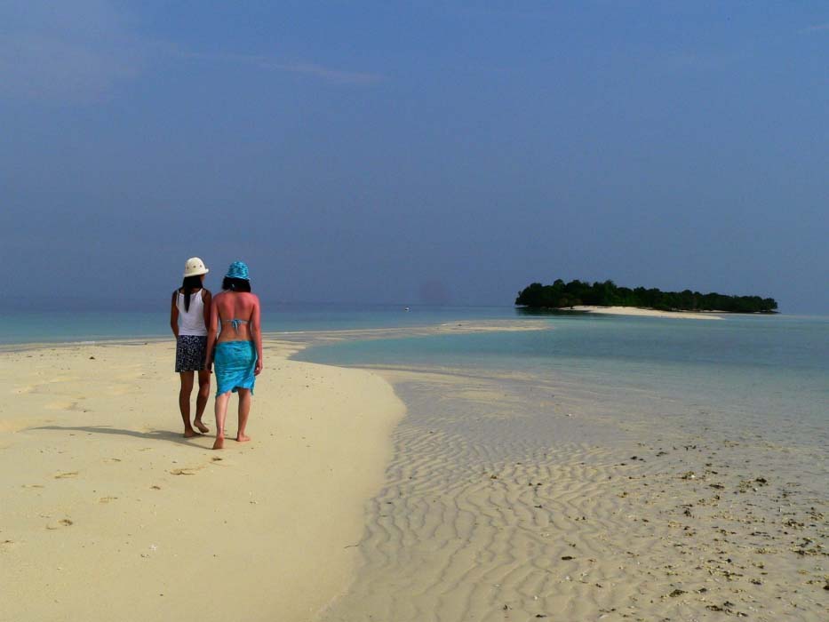 Beautiful aerial view of the smaller Mataking Kecil island, connected to the main island by a pristine white sandbar at low tide.