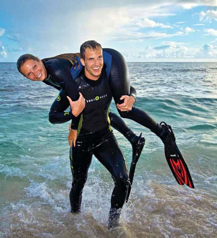 Scuba diver practicing in-water rescue breathing techniques on a simulated victim during a PADI Rescue Diver course in Mabul.