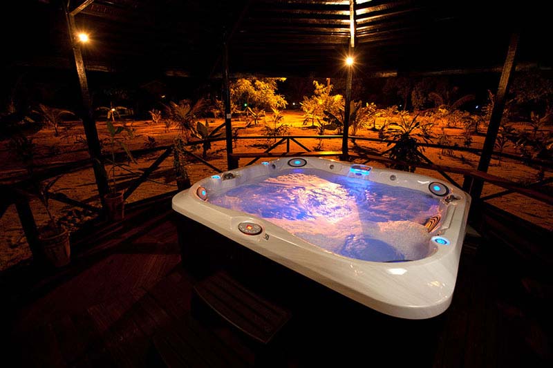Relaxing in the illuminated outdoor jacuzzi at night at the Yin & Yang Spa, a luxurious amenity at the 5-star Pom Pom Island Resort.
