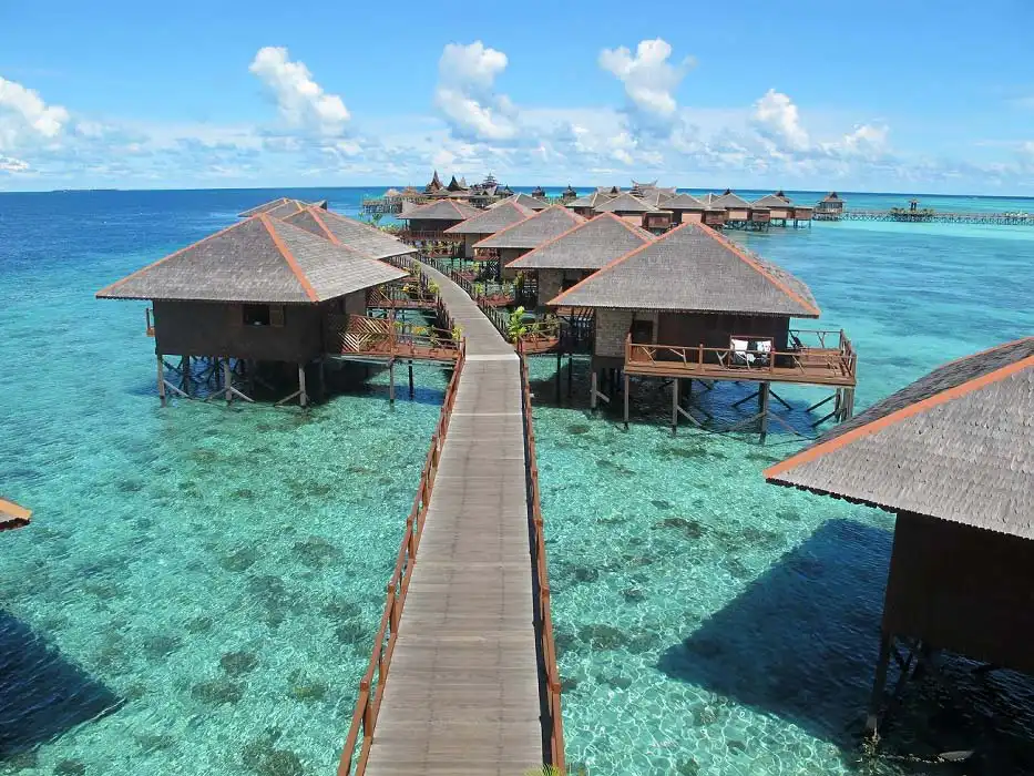 Breathtaking view of the iconic Sipadan Water Village resort, with its overwater bungalows forming a beautiful flower shape over the turquoise shores of Mabul island.