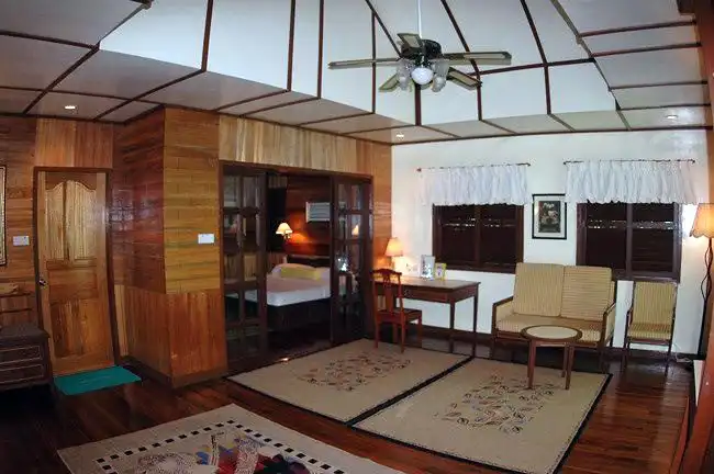 Spacious interior of a beachfront Suite Chalet at Sipadan-Mabul Resort, offering a separate sleeping area and a large living space perfect for families with kids.