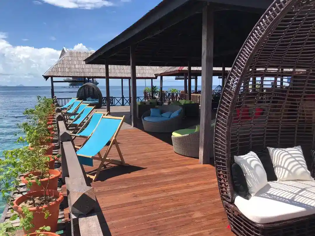 Relaxing open-air jetty lounge at Borneo Divers Resort on Pulau Mabul, with comfortable seating perfect for enjoying the sea breeze after a day of diving.