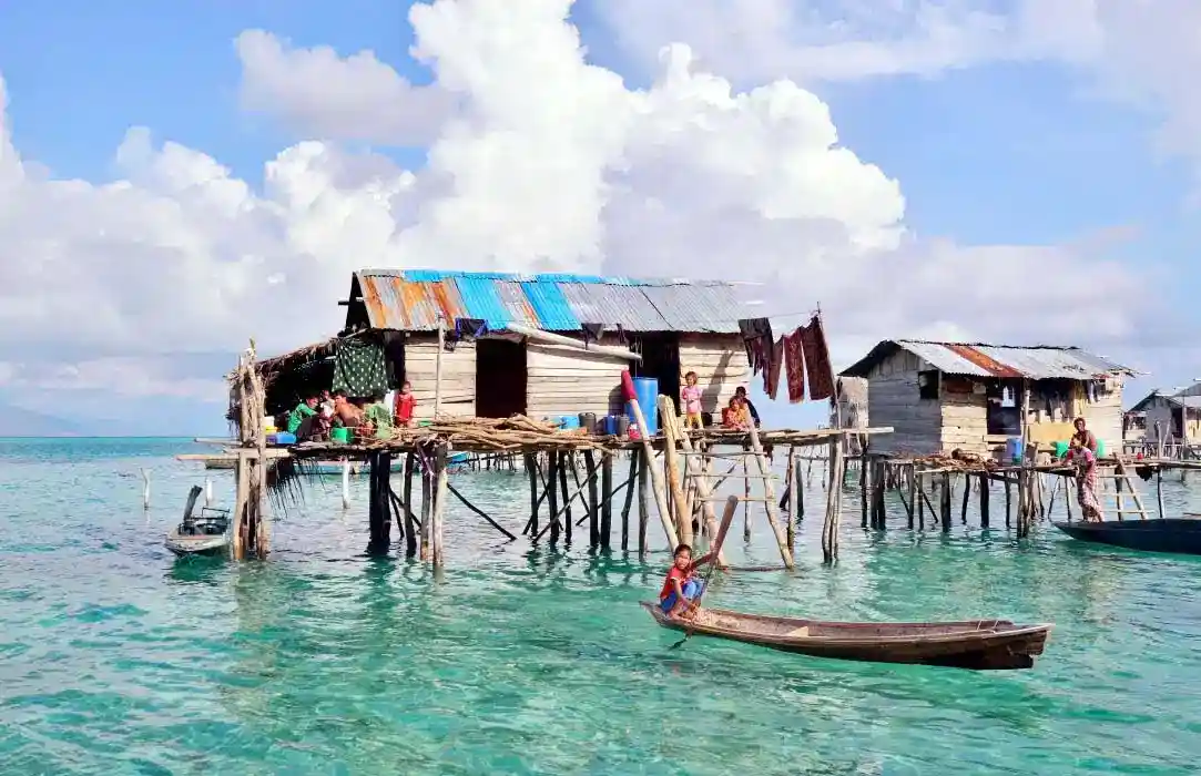 Traditional wooden stilt house of the Bajau Laut sea nomads, built over the clear turquoise waters of the Celebes Sea.